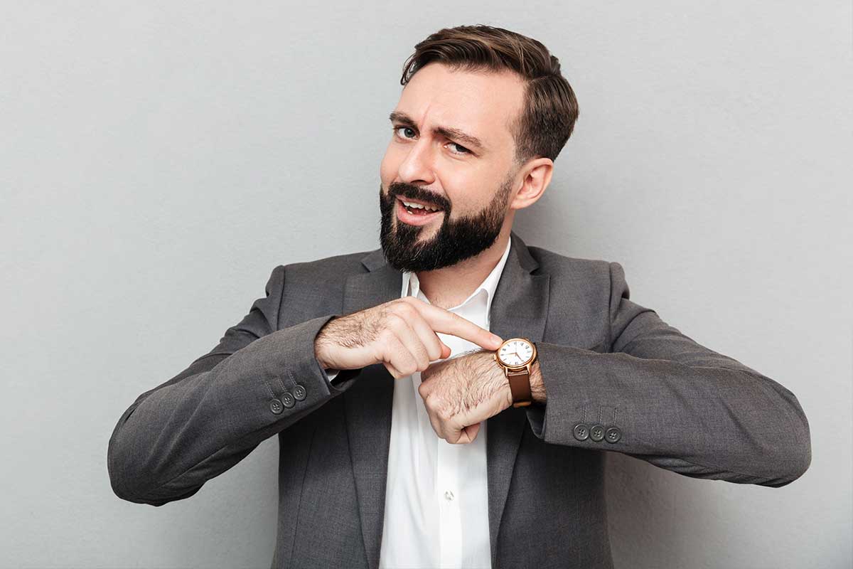 Mężczyzna wskazuje na zegarek z powodu późnej pory